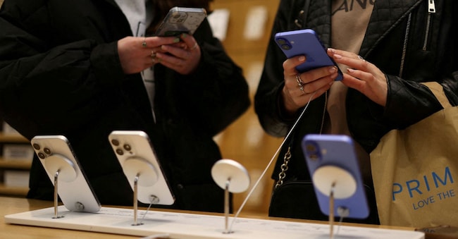  Persone utilizzano uno smartphone Apple iPhone in un negozio di Londra, Gran Bretagna, 6 ottobre 2024. REUTERS/Hollie Adams/Foto d'archivio