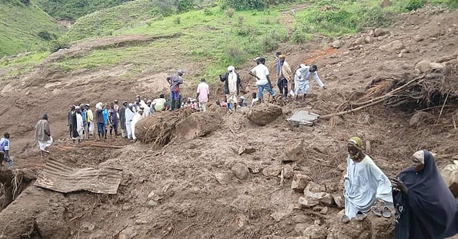 Questa immagine distribuita dal Movimento/Esercito di Liberazione del Sudan (Sl,m), il 2 settembre 2025, mostra persone che ispezionano i detriti dopo che una frana ha devastato il villaggio di Tarasin, nella zona sudanese di Jebel Marra. (Susan Liberation Movement/Army/Afp)