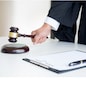 Male Judge lawyer In A Courtroom Striking The Gavel on sounding block.