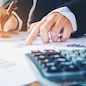 Businessman's hands with calculator at the office and Financial data analyzing counting on wood desk