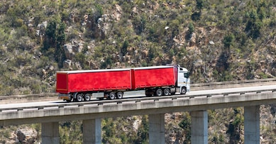 Bloukrans Bridge, Eastern Cape, South Africa. Dec 2019. Bloukraans Bridge carrying a toll road 216 metres above the gorge  Passing over a red truck and trailer.