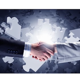 Close up of business handshake with puzzle elements at background