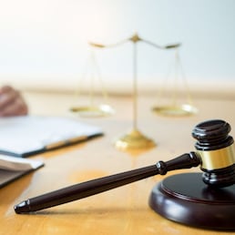 Male lawyer working with contract papers and reading law book in a courtroom, justice and law concept while presiding over trial