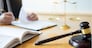 Male lawyer working with contract papers and reading law book in a courtroom, justice and law concept while presiding over trial