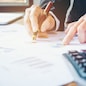 Businessman's hands with calculator at the office and Financial data analyzing counting on wood desk