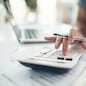 Finance planning, budget or savings manager calculating expenses, taxes or company profits with laptop, paperwork or calculator. Closeup hands of female financial leader checking office staff payroll.