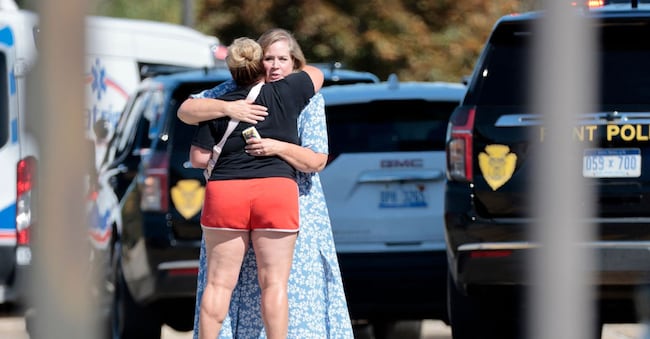 Persone abbracciate vicino alla  chiesa di Grand Blanc, Michigan, teatro della sparatoria