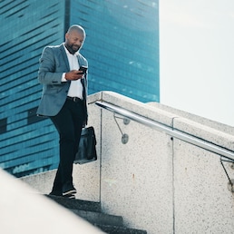 Black man, walking and stairs with phone for commute, business trip or corporate travel in city. Businessman, briefcase and staircase with mobile smartphone for career destination or job opportunity.