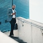 Black man, walking and stairs with phone for commute, business trip or corporate travel in city. Businessman, briefcase and staircase with mobile smartphone for career destination or job opportunity.