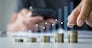 Savings and Investment concept. Concept of saving money for finance accounting to arrange coins into growing graphs concept. businessman holding a coin putting on stack coins.