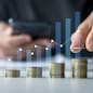 Savings and Investment concept. Concept of saving money for finance accounting to arrange coins into growing graphs concept. businessman holding a coin putting on stack coins.
