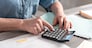 Female accountant using calculator in office