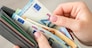 Close up of female hands holding grey wallet with 20 and 50 euro banknotes. Purchases, business, finances concept