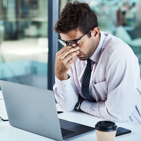 Stress, headache and man on laptop in office frustrated with glitch, mistake or crisis. Anxiety, migraine and male business person angry with failure, 404 or bad review, deadline report or tech delay.