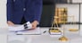 Lawyer woman holding document and working about business contract with brass balance scales on desk.