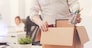 Nothing left behind. Attentive dedicated fired man packing his stuff in a box as he cleaning his workplace before leaving the office