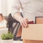 Nothing left behind. Attentive dedicated fired man packing his stuff in a box as he cleaning his workplace before leaving the office