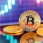 Gold Bitcoin crypto currency on background of chart diagram.