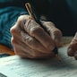 Close-up of an old man's hand studying and signing his last will and testament. Last will and testament concept