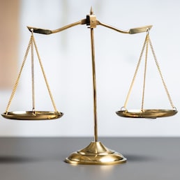 Shiny golden balanced scale in court library background as concept justice and fairness legal symbol. Scale balance for righteous and equality judgment by lawyer and attorney. equility