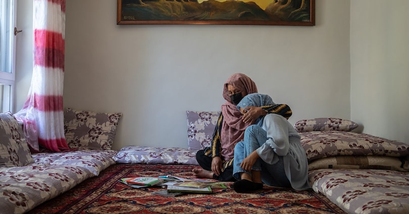 L'8 giugno 2024, Lateefa*, 42 anni, conforta la figlia Zainab* che piange e non va a scuola da tre anni. Lateefa ha cinque figli, due maschi e tre femmine.  "Avevo molti sogni, proprio come mia figlia, ma non sono riuscita a vederli realizzati. La nostra famiglia è fuggita dall'Afghanistan dopo la presa di potere dei Talebani nel 1996 e io ho dovuto lasciare la mia scuola quando frequentavo la prima media".  "Zainab piangeva spesso ed è diventata molto depressa da quando non va più a scuola. Cerchiamo di confortarla mandandola a frequentare un corso di inglese e di sostenerla il più possibile".  "Sono molto preoccupata per il suo benessere. Si sente molto sola a non vedere i suoi amici".  "Credo che sia molto importante che le ragazze ricevano un'istruzione. Ho fatto esperienza di una vita senza istruzione. È molto difficile. Non posso nemmeno aiutare i miei figli a studiare e questo mi ferisce profondamente".  *I nomi sono stati cambiati. (© UNICEF/UNI590567/Amin Meerzad)