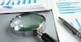 TRN4TB Magnifying glass and business report for auditing.