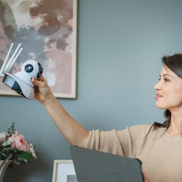 One woman use digital tablet to adjust install home security camera
