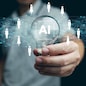 AI technology for HR, Human resources. A man holds lightbulb with artificial intelligence chip in it representing using Ai and automation to manage and recruit employees. Automate the hiring process