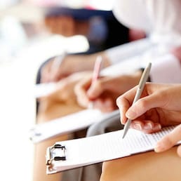 Businesspeople hands over papers making notes at seminar