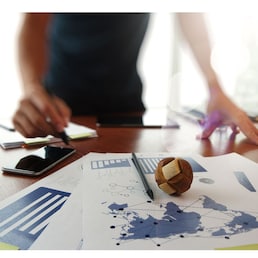 Moving Image of Business creative designer working wooden texture globe with smart phone on business document in office desk as internet concept