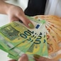 hands of a young beautiful girl hand over a large sum of new euro bills. Business concept