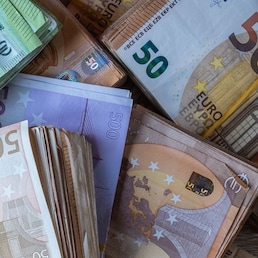 Bundles of European banknotes tied with rubber bands.