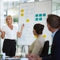 Presentation, woman and whiteboard with staff in office for workflow steps, diagram and teamwork for web design. Female speaker, people and meeting of strategy process, chart and interface project.