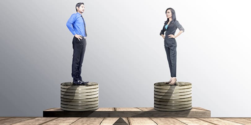 Asian businessman and businesswoman standing on coins stack with same height on balancer. Equality gender concept