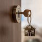 Open door to a new home with key and home shaped keychain. Mortgage, investment, real estate, property and new home concept