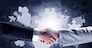 Close up of business handshake with puzzle elements at background