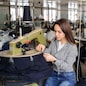 close up photo of a young man and a woman working with linking machine for knitting in textile industry
