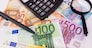 different euro banknotes, calculator, magnifier and pen. Financial concept.