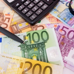 different euro banknotes, calculator, magnifier and pen. Financial concept.