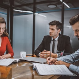 Studying documents. A couple reading legal papers in a lawyers office