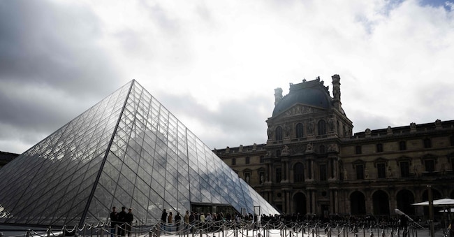 Tourists queue to enter the Louvre museum next to the Louvre pyramid designed by Chinese-US architect Ieoh Ming Pei, in Paris, on November 3, 2025.