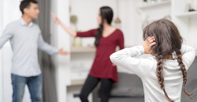 Domestic violence and Family conflict concept. Sadness little girl against blured of mother fighting father with quarrel at home.