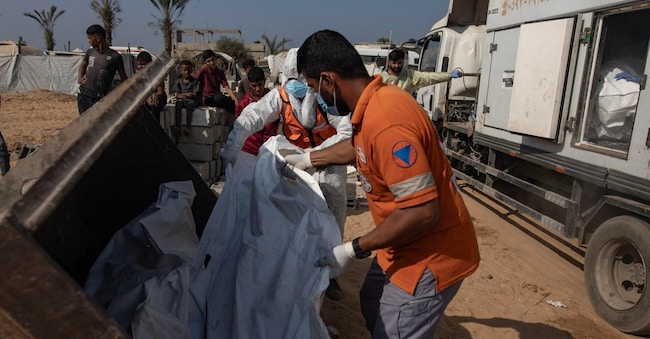I resti e i corpi di palestinesi non identificati, restituiti da Israele, vengono deposti in una fossa comune durante la loro sepoltura a Deir al-Balah, nella Striscia di Gaza centrale, il 10 novembre 2025. Israele ha restituito i corpi e i resti di palestinesi non identificati a Gaza, nell’ambito di un accordo di cessate il fuoco. EPA/HAITHAM IMAD