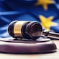 Judges wooden gavel with EU flag in the background. Symbol for jurisdiction.