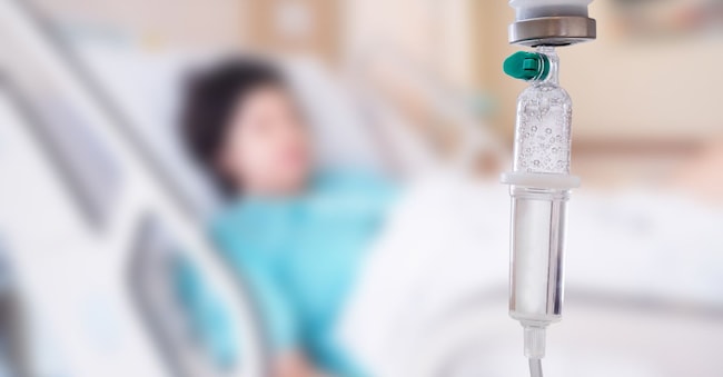 Medical drip with patient in the hospital blurred background