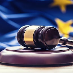 Judges wooden gavel with EU flag in the background. Symbol for jurisdiction.