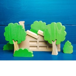 Industrial factory plant hidden behind the trees. Greenwashing concept. PR and trend about caring for environment. Misleading customers and buyers of products and maximizing profits. Hiding facts