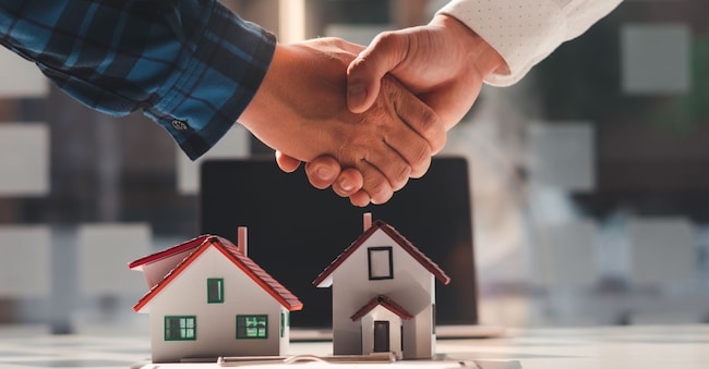 The real estate agent is explaining the house style to the clients who come to contact to see the house design and the purchase agreement, Mortgage loan approval home loan and insurance concept.