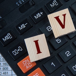 IVA (Individual Voluntary Arrangement) - acronym on wooden cubes on the background of a calculator. Business concept