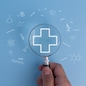 Healthcare access and wellness Medical care concept with a magnifying glass, family, and plus sign icons.
